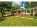 Charming brick home with a well-manicured lawn and flowering shrubs, offering classic curb appeal at 6018 Ridgecrest Ave, Hanahan, SC 29410