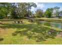 Expansive backyard boasts lush green lawn, fenced in fire pit area, and serene water views at 68 Oyster Point Row, Charleston, SC 29412