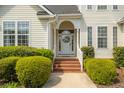Inviting front porch with decorative wreath, brick steps, and manicured shrubbery at 68 Oyster Point Row, Charleston, SC 29412