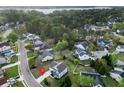 An aerial view of the neighborhood showcasing the home's location among lush greenery and a nearby lake at 7483 Hawks Cir, Hanahan, SC 29410