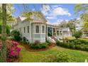 Charming light blue two-story home with a landscaped yard and mature trees along the perimeter of the property at 803 S Main St, Summerville, SC 29483