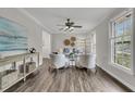 Elegant living room with hardwood floors, decorative ceiling fan, and abundant natural light from large windows at 811 E Estates Blvd, Charleston, SC 29414