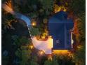 Aerial night view of an estate with a winding drive and illuminated grounds at 83 Blue Heron Pond Rd, Kiawah Island, SC 29455
