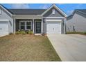 Charming gray home with a well-maintained lawn, front porch, and an attached garage at 832 Descartes St, Summerville, SC 29486