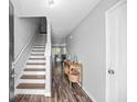 Inviting entryway with stylish wood floors leading to the living areas, stairs, and kitchen at 9727 Transplanter Cir, Ladson, SC 29456