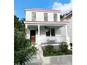 Charming two-story home featuring a red metal roof, welcoming front porch, and beautiful flower beds at 10 Killians St, Charleston, SC 29403