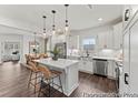 Bright kitchen with marble backsplash, island with seating, stainless steel appliances, and wood floors at 1007 Toland Dr # 45P, Saint George, SC 29477