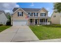 Inviting two-story home featuring a charming front porch and a well-maintained lawn at 106 Gathering Island Rd, Summerville, SC 29485