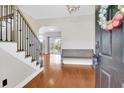 Welcoming foyer with hardwood floors, elegant staircase, and bench seating at 106 Gathering Island Rd, Summerville, SC 29485