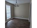 Bright living room featuring wood-look floors, neutral walls, and a modern chandelier at 108 Sandlewood Dr, Summerville, SC 29483