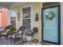 Inviting front porch featuring wicker rocking chairs, plants, and a decorative door with a welcoming wreath at 123 Hyacinth St, Summerville, SC 29483