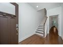 Welcoming foyer with hardwood floors, staircase, white walls, and modern door hardware creating a bright space at 1271 Dingle Rd, Mount Pleasant, SC 29466