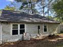 Exterior side view of a house with white siding, windows, and dark roof surrounded by lush greenery at 143 Mickler Dr, Ladson, SC 29456