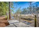 A wooden walkway overlooking the scenic marshland, lined with trees on a sunny day at 155 Winding River Dr, Johns Island, SC 29455
