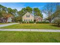 Inviting two-story home with tan siding, brick accents, and a lush green lawn under a clear blue sky at 177 Thousand Oaks Cir, Goose Creek, SC 29445