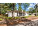 Single-story home featuring a screened-in porch and mature trees in a natural setting at 1778 Brockington Ave, Charleston, SC 29407