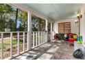 Covered front porch providing a shaded seating area with view of tree lined yard at 1778 Brockington Ave, Charleston, SC 29407