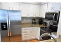 Modern kitchen featuring stainless steel appliances, granite countertops, and white cabinets at 2 Pelican Reach # Share 11, Isle of Palms, SC 29451