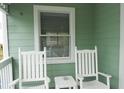 Inviting porch featuring rocking chairs and a small table, perfect for relaxing and enjoying the outdoors at 2 Pelican Reach # Share 11, Isle of Palms, SC 29451