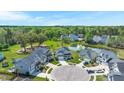 Aerial view of homes in a neighborhood featuring a pond, mature trees, and well-maintained lawns at 215 Center Hill Ct, Summerville, SC 29485