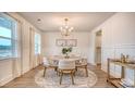 Cozy dining room with wainscoting, a round table, and a modern chandelier for an inviting atmosphere at 217 Bilge Rd, Ridgeville, SC 29472