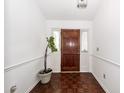 Inviting foyer with hardwood flooring, white walls, and a wooden front door with decorative plant at 2441 Hansard Dr, North Charleston, SC 29406