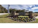 Welcoming entrance to Carolina Groves with brick signage and colorful flowerbeds at 293 Blue Haw Dr, Moncks Corner, SC 29461
