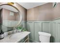 Charming powder room with marble counter, decorative wallpaper, and round mirror at 3 Queen St # 315, Charleston, SC 29401