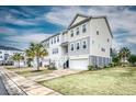 A row of well-maintained townhomes with white siding, complemented by lush green lawns and swaying palm trees at 307 Lanyard St, Johns Island, SC 29455