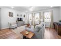 Bright living room with cozy seating, hardwood floors, and large windows with sheer curtains at 307 Lanyard St, Johns Island, SC 29455