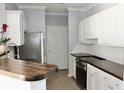 Bright kitchen featuring white cabinets, stainless steel refrigerator and wood countertops at 45 Sycamore Ave # 1327, Charleston, SC 29407
