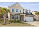 Charming two-story home featuring a stone and vinyl facade, attached garage, and a well-manicured lawn at 470 Gianna Ln, Goose Creek, SC 29445