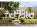 Elegant stone facade home with manicured lawn, symmetrical shrubbery, and tiled roof at 478 Huger St, Charleston, SC 29403
