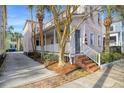 Lovely home with a covered porch, brick steps, and lush landscaping at 5 Kracke St # A, Charleston, SC 29403