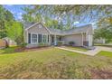 Traditional single-story home with tidy landscaping, a concrete driveway, and a cozy front entrance at 5033 Thornton Dr, Summerville, SC 29485