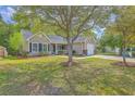 Well-kept home with a green lawn, mature trees, and an attached one-car garage, presenting a welcoming curb appeal at 5033 Thornton Dr, Summerville, SC 29485