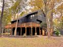 Striking dark home exterior featuring an expansive wraparound deck and fall foliage at 6464 St Anthony Dr, Hollywood, SC 29449