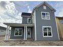 New two-story home featuring gray siding, white trim, a covered porch, and bright windows at 717 Blueway Ave, Summerville, SC 29486