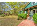 View of home, trees and brick walk-up to the covered front porch at 755 Jumbo Ln, Edisto Island, SC 29438