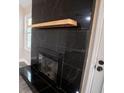 Close-up of fireplace with sleek black tile surround and natural wood mantle at 780 Corral Dr, Charleston, SC 29414