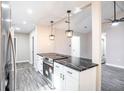Kitchen featuring modern black marbled countertops, stainless appliances, and stylish pendant lighting at 780 Corral Dr, Charleston, SC 29414