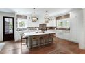 Spacious kitchen featuring white cabinets, brick backsplash, a large center island, and modern lighting at 825 Marsh Grove Ave, Mount Pleasant, SC 29464