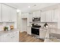 Well-lit kitchen boasts white cabinets, modern appliances, a tiled backsplash, and durable flooring at 1008 Drakeford St # 4P, Saint George, SC 29477