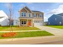 Charming two-story home with a landscaped yard, two-car garage, and an inviting orange front door at 1017 Marsh Harrier Dr # Cc3-3-3, Ravenel, SC 29470
