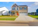 Beautiful two-story home features a manicured lawn, two-car garage and a cheerful orange front door at 1017 Marsh Harrier Dr # Cc3-3-3, Ravenel, SC 29470