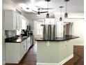 Modern kitchen with white cabinetry, black countertops, stainless steel appliances, and bar seating at 1026 Stono River Dr, Charleston, SC 29412