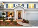 Charming front porch with rocking chairs, hanging ferns, and a decorative wreath on the front door at 119 Loon Dr, Summerville, SC 29483