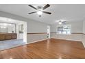 Open floorplan living room with hardwood floors, ceiling fans, and seamless access to dining area at 1318 Foster St, Charleston, SC 29407