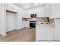Open kitchen featuring white cabinets, stainless steel appliances, subway tile backsplash, and modern light fixtures at 229 Night Heron St # 602, Summerville, SC 29486