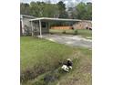 Exterior with a covered carport and a well-maintained green lawn, complete with a small stream and trees at 233 N Pandora Dr, Goose Creek, SC 29445